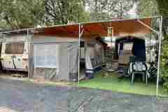 Lakókocsi elősátorral és árnyékoló tetővel